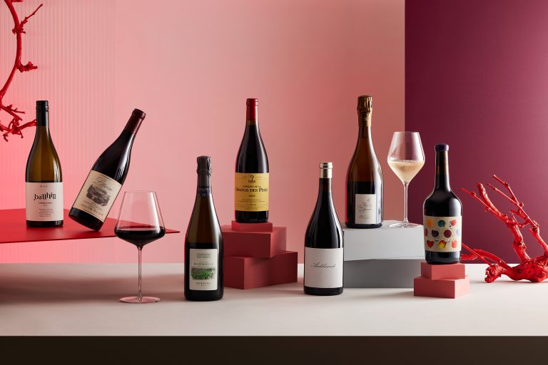 wine bottles photographed on red background by sarah anderson photography 768x512